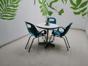 uma mesa e quatro cadeiras num quarto em Aveiro Hotel em Cúcuta