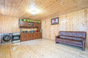 a living room with a leather couch and a kitchen at Babi & Tata's House in Ushguli