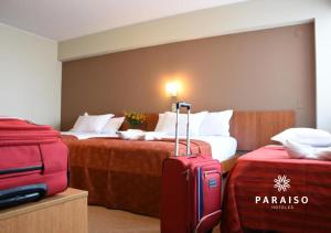 une chambre d'hôtel avec 2 lits et des valises dans l'établissement Hoteles Paraiso TRUJILLO, à Trujillo