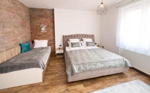 um quarto com duas camas e uma parede de tijolos em Luxurious and Cosy Brick Apartment - Free private parking em Saraievo mais 27 fotografias