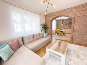 uma sala de estar com um sofá e uma parede de tijolos em Luxurious and Cosy Brick Apartment - Free private parking em Saraievo