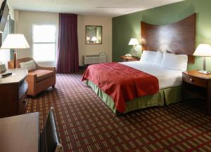 Habitación de hotel con cama y silla en Select Inn Murfreesboro, en Murfreesboro