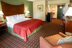 una habitación de hotel con una cama grande y una silla en Select Inn Murfreesboro, en Murfreesboro