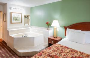 Habitación de hotel con bañera y cama en Select Inn Murfreesboro, en Murfreesboro