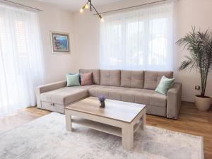 a living room with a couch and a coffee table at Luxurious and Cosy Brick Apartment - Free private parking in Sarajevo