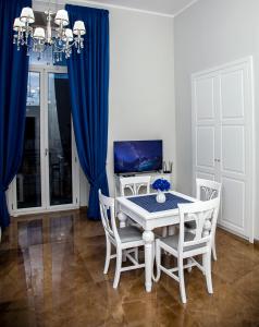 uma sala de jantar com cortinas azuis e uma mesa e cadeiras em Villa Giuseppina em Nápoles