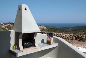 a small white house with a fireplace on the roof at Résidence Santa Monica in Bonifacio