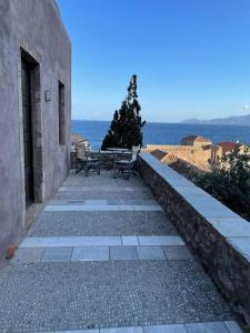 a walkway leading to a building with a table and bench at Daphne superior castle suite in Monemvasia