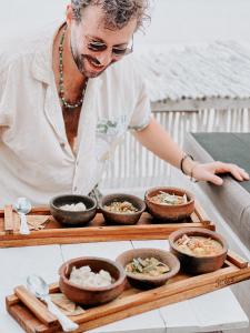 a man standing in front of a tray with bowls of food at The Seles Boutique Hotel in Matemwe