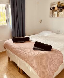 two towels are sitting on a bed in a bedroom at Click&Guest - Casa Queer in Maspalomas