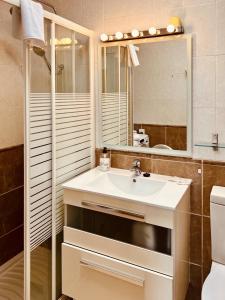 a bathroom with a sink and a mirror at Click&Guest - Casa Queer in Maspalomas