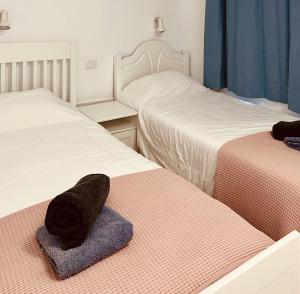 a bedroom with two beds and a hat on the bed at Click&Guest - Casa Queer in Maspalomas