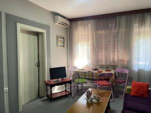een woonkamer met een tafel en stoelen bij Central City Touch in Skopje