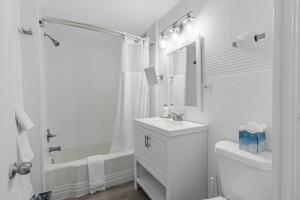a white bathroom with a sink and a toilet at House at Phipps in Atlanta +78 photos