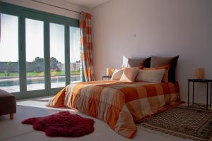 ein Schlafzimmer mit einem Bett und einem großen Fenster in der Unterkunft WINK house : Charme et Sérénité in Essaouira
