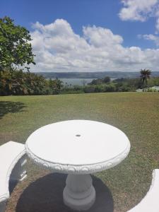a white table sitting on top of a grass field at Lakeview Arenal 1 Bed Suite, Communal Pool & Gym - 2024 Traveller Awards Winner in Tronadora