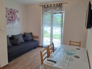 a living room with a blue couch and a table at Apartments Neli in Vinišće