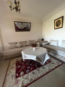 a living room with a table and a couch at Asilah Marina Golf in Asilah