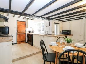 a kitchen with a wooden table and a dining room at Vintner's Cottage in Norwich