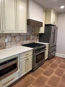 uma cozinha com electrodomésticos de aço inoxidável e armários brancos em Spanish Charm 4bed/3bath em Waupaca