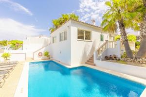 a villa with a swimming pool in front of a house at Villa Palmera in Alaior