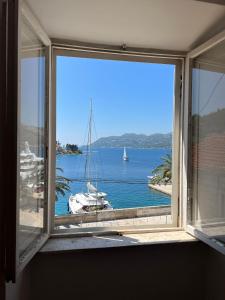 a window with a view of a boat in the water at Apartman Aterina in Korčula