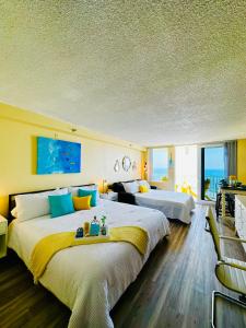 a hotel room with two beds and a couch at Oceanfront Oasis in Daytona Beach