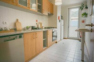 una cucina con armadi in legno e pavimento piastrellato bianco di Kora Home a Santa Cruz