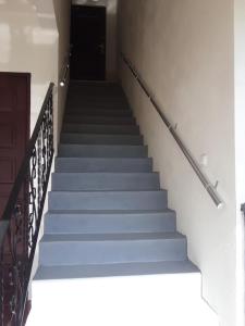 eine Treppe mit blauen Stufen und einer schwarzen Tür in der Unterkunft Guest House Buche on Agmashenebeli 219 in Kobuleti