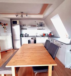 a kitchen with a wooden table and chairs in it at Stilvolle hochwertige Wohnung im Stadtzentrum in Jena