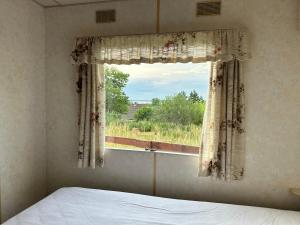 um quarto com uma cama e uma janela com vista em Domek za świerkami em Charzykowy