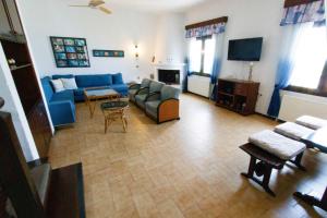 sala de estar con sofá azul y TV en Villa Paradiso, en Neos Marmaras