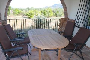 einen Holztisch und Stühle auf dem Balkon in der Unterkunft Alleinstehende Villa mit Pool-Finca Gabriela in Oliva