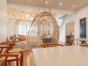 オーシャン・グローブにあるBeachliner Hotelの白いテーブルと椅子、大きなシャンデリアが備わる客室です。