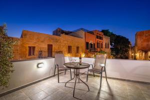 a patio with a table and chairs in front of a building at Nikolas Old Town in Rhodes Town