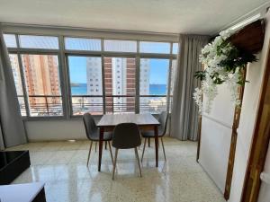 a dining room with a table and chairs and a large window at Apartamento Coblanca 6 in Benidorm