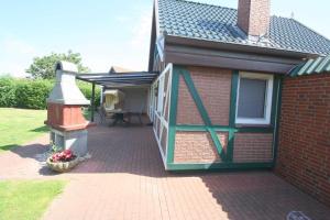 a brick house with a patio with a bird feeder at FH Norderpiep 22 Sauna u Kamin in Friedrichskoog-Spitze