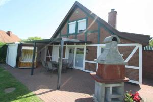 a house with awning and a fire hydrant in the yard at FH Norderpiep 22 Sauna u Kamin in Friedrichskoog-Spitze