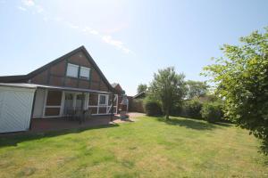 a house with a yard in front of it at FH Norderpiep 22 Sauna u Kamin in Friedrichskoog-Spitze +27 photos