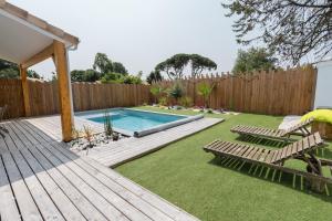 een achtertuin met een zwembad en een houten hek bij * * La maison du bonheur * * Piscine chauffée in Fargues-Saint-Hilaire
