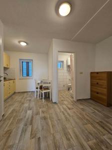 an empty kitchen and dining room with a table in it at Apartman Lila in Čunski