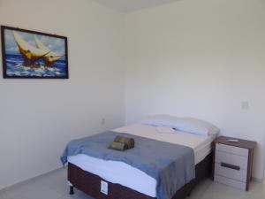 プレアにあるSol Apartamento 4 - Quarto e sala com varanda e cozinha americana na praia do prea-CEのベッドルーム1室(ベッド1台付)が備わります。壁に絵が飾られています。