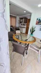 uma sala de jantar com uma mesa de vidro e cadeiras em Janeth’s Place Apartamento em San Andrés