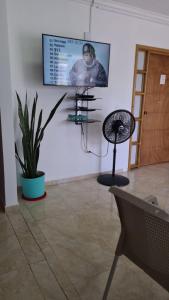 a room with a tv on the wall and a fan at Janeth’s Place Apartamento in San Andrés