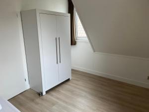 a white cabinet in a room with a window at Bello in Opperdoes