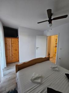 a bedroom with a bed with two towels on it at Apartman Lila in Čunski