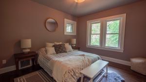 a bedroom with a bed and two windows at Spanish Charm 4bed/3bath in Waupaca