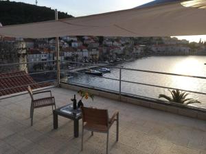 eine Terrasse mit 2 Stühlen und einem Tisch mit Flussblick in der Unterkunft Korčula Sunset apartman in Korčula