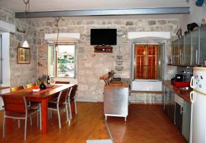 a kitchen with a wooden table and a dining room at Korčula Sunset apartman in Korčula