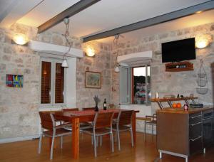 uma cozinha e sala de jantar com mesa e cadeiras em Korčula Sunset apartman em Korčula